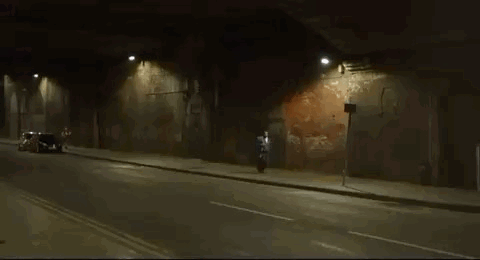 Man Riding Motorcycle in Tunnel at Night