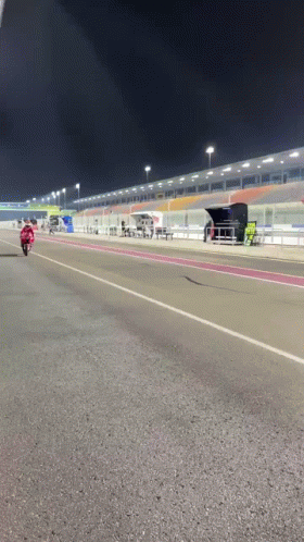 Man Riding Motorcycle on Race Track at Night