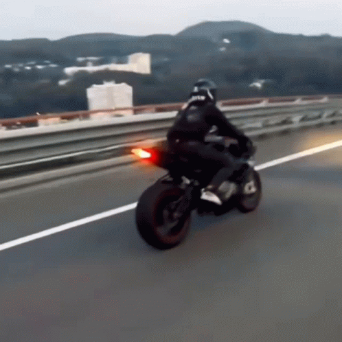 Man Riding Motorcycle With RTR on Back