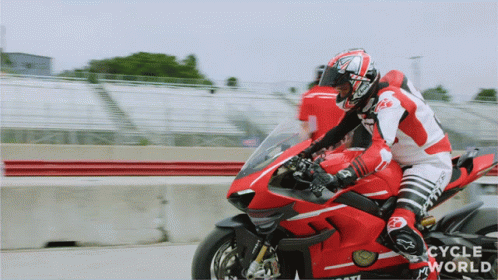 Man Riding Red and White Motorcycle Cycle World