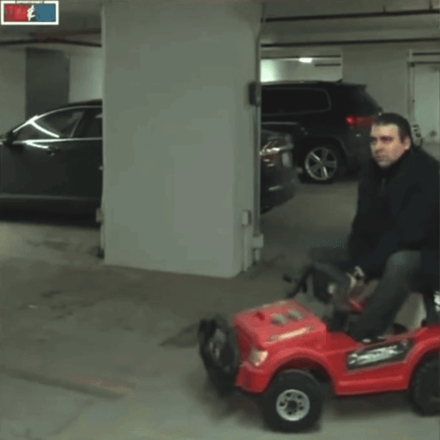 Man Riding Red Car with Tim Sid Sign