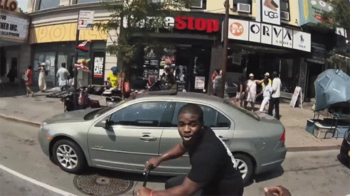 Man Riding Scooter in Front of Free Stop Store