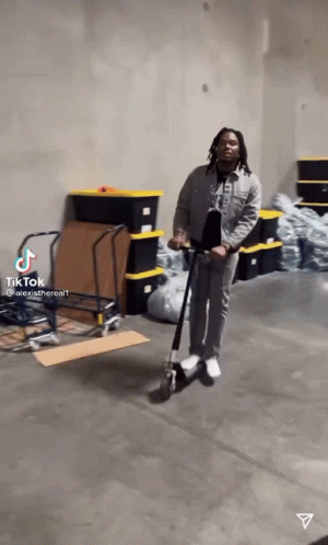 Man Riding Scooter In Warehouse GIF
