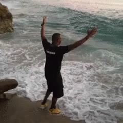 Man Running Away From Ocean Waves GIF