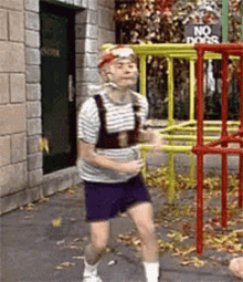 Man Running In Front Of Playground Sign Saying No Dogs GIF