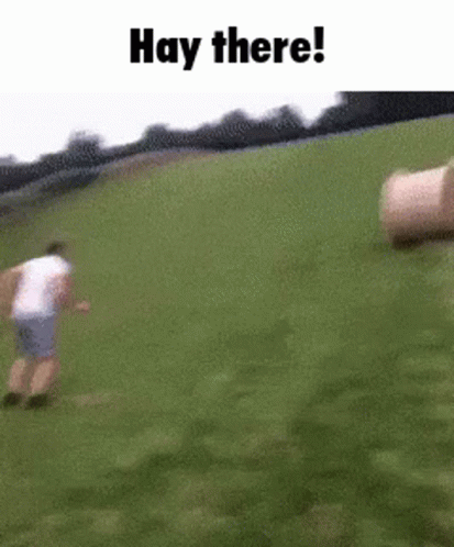 Man Running in Grassy Field with Hay Bales