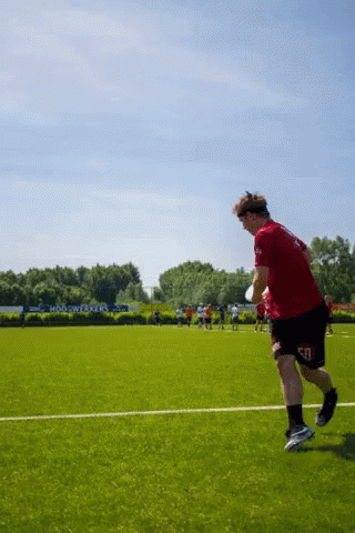 Man Running On Field In Red Shirt And Black Shorts GIF