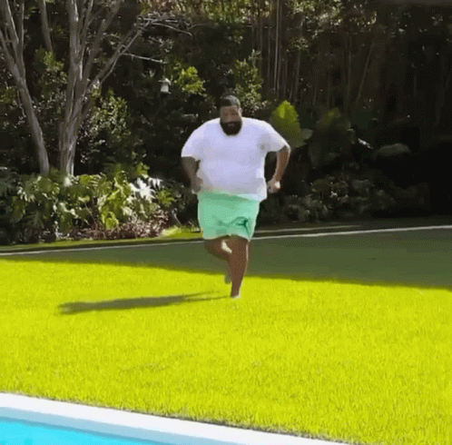 Man Running on Green Lawn