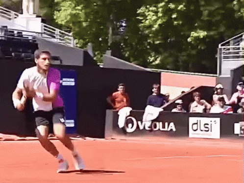 Man Running on Tennis Court With DLSI Sign