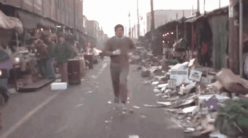 Man Running Past Pile of Cardboard Boxes