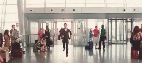 Man Running Through Airport With Exit Sign