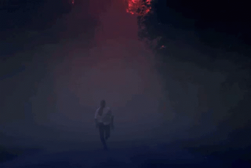 Man Running Through Foggy Forest at Night