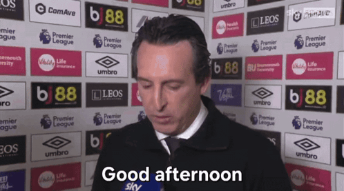 Man Saying Good Afternoon in Front of Advertisement Wall