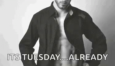 Man Shirtless in Front of Its Tuesday Sign