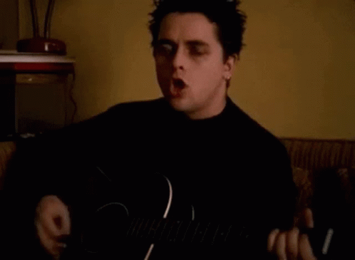 Man Singing And Playing Guitar In Dark Room GIF