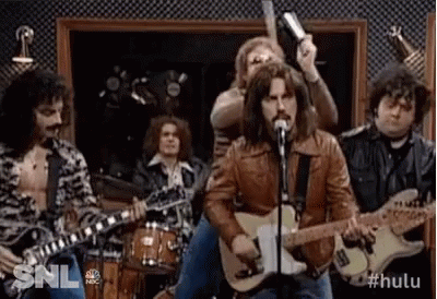 Man Singing Guitar Into Microphone With Drummers
