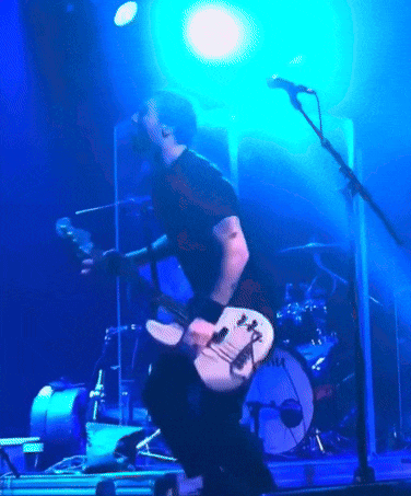 Man Singing into Mic Playing Guitar with Tama Drums
