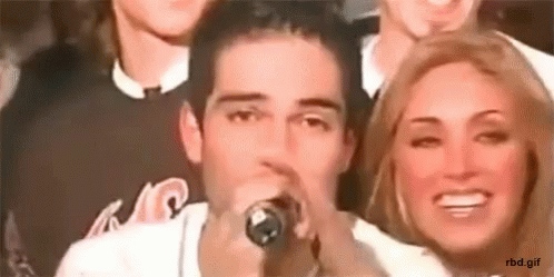 Man Singing Into Microphone Beside Woman