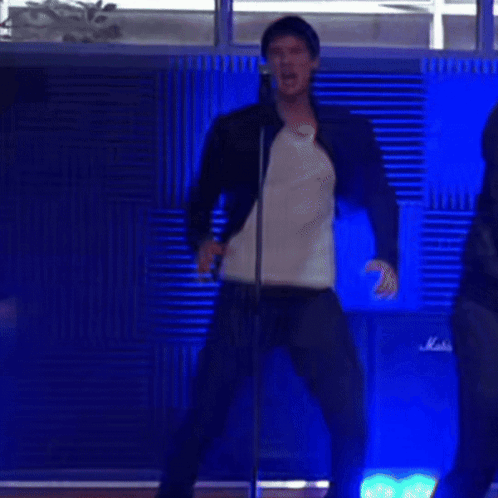 Man Singing Into Microphone Dancing Beside Marshall Amp