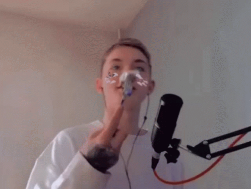 Man Singing Into Microphone Holding Fork in Mouth