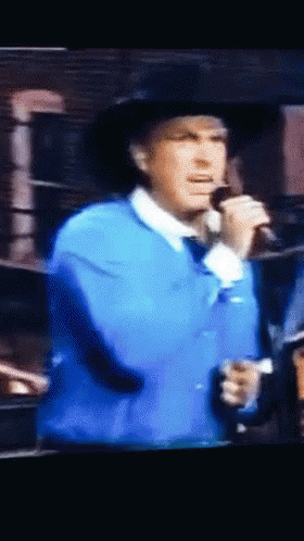 Man Singing Into Microphone In Blue Jacket GIF