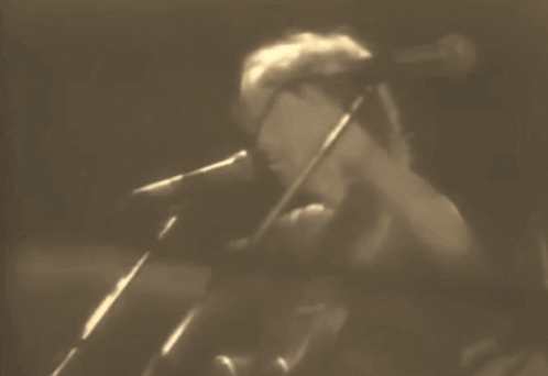 Man Singing into Microphone in Dark Room