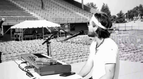 Man Singing Into Microphone in Empty Bleachers