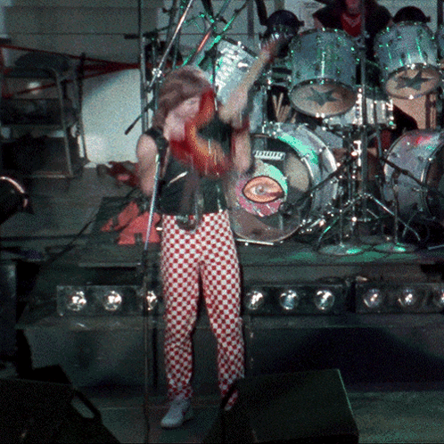 Man Singing Into Microphone in Front of Ludwig Drum Set