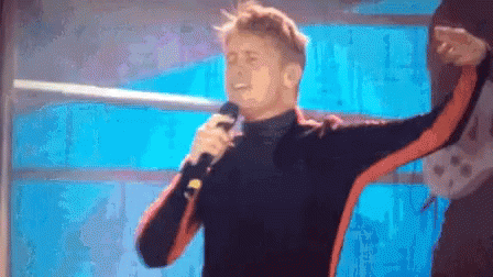 Man Singing Into Microphone In Front Of Window GIF