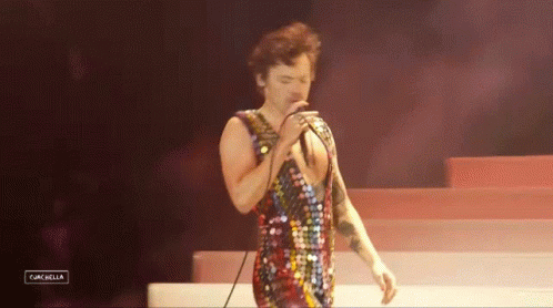 Man Singing Into Microphone In Sequined Outfit GIF