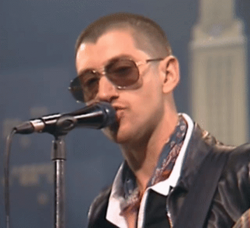 Man Singing Into Microphone in Sunglasses and Leather Jacket