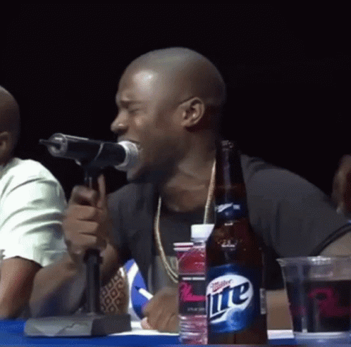 Man Singing Into Microphone Next to Miller Lite