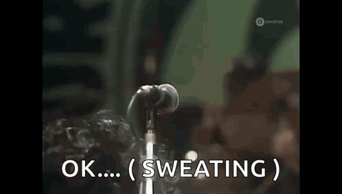 Man Singing into Microphone Ok Sweating