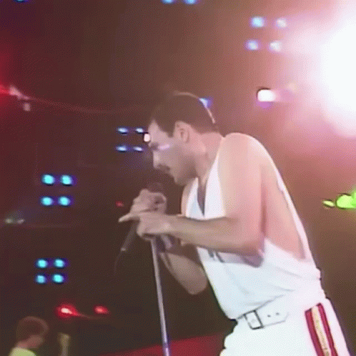 Man Singing Into Microphone on Stage