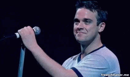 Man Singing into Microphone on Stage