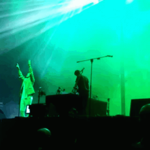 Man Singing Into Microphone on Stage