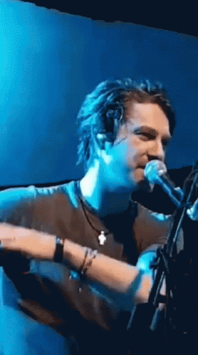 Man Singing Into Microphone on Stage