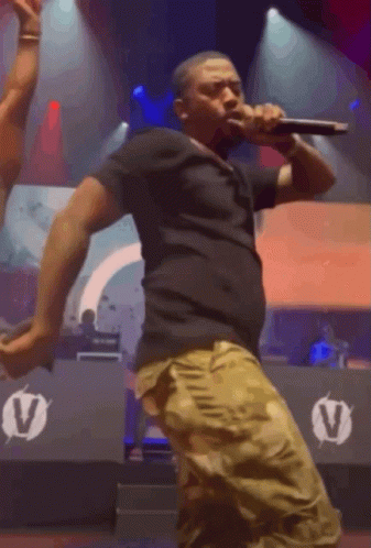 Man Singing Into Microphone on Stage
