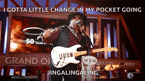 Man Singing Into Microphone Playing Guitar Gotta Little Change In My Pocket