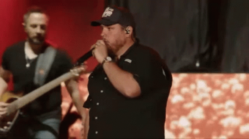 Man Singing Into Microphone Playing Guitar On Stage GIF