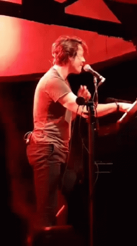 Man Singing Into Microphone Playing Keyboard