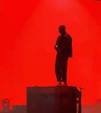 Man Singing Into Microphone Red Backdrop