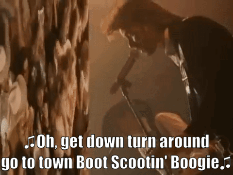 Man Singing Into Microphone Saying Oh Get Down Turn Around Go To Town Boot Scootin Boogie