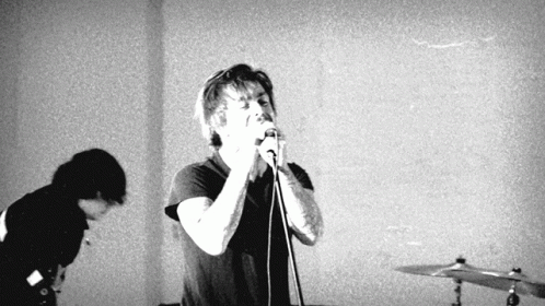 Man Singing Into Microphone While Another Watches GIF
