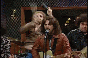 Man Singing Into Microphone With Drummer