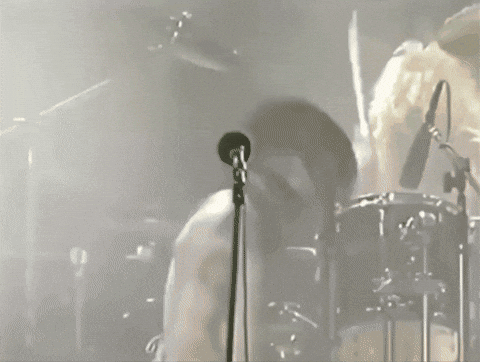 Man Singing Into Microphone With Drummer GIF