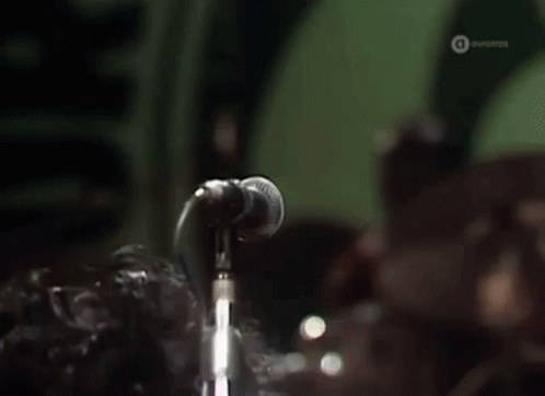 Man Singing Into Microphone With Eyes Closed