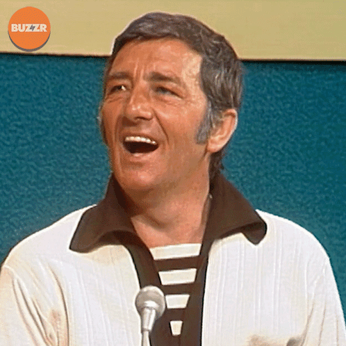 Man Singing Into Microphone With Orange Buzzr Logo GIF