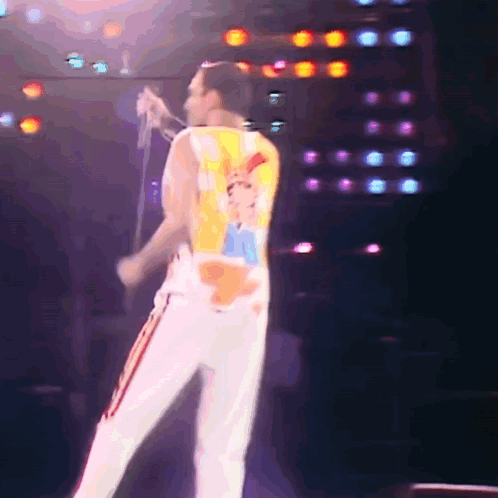 Man Singing Into Microphone With Queen Shirt