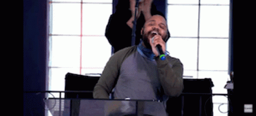 Man Singing Into Microphone Woman Behind Him